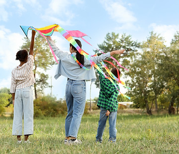 Mother with her children flying kite in park, back view.jpg