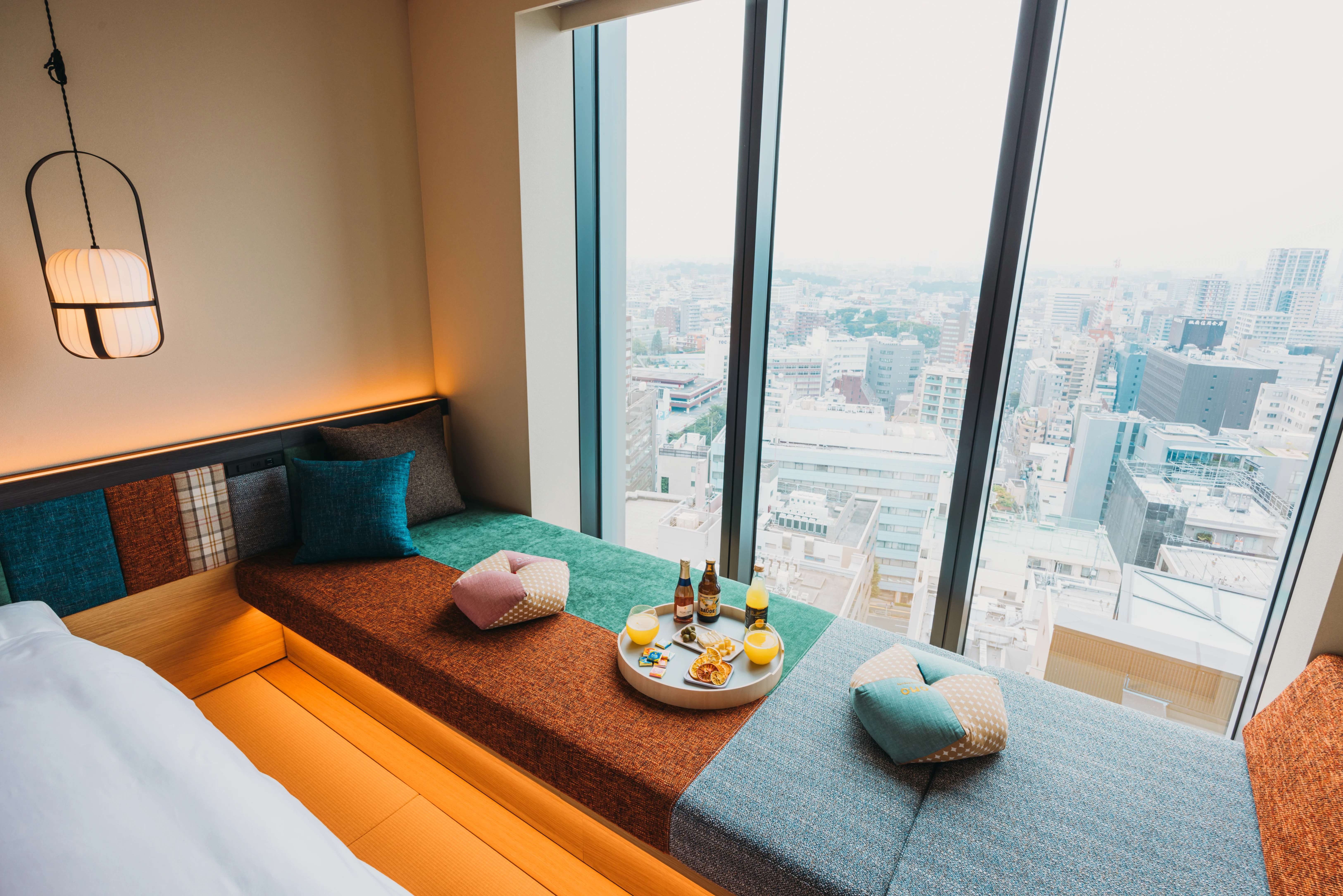 OMO5 Tokyo Gotanda twin room with floor-to-ceiling windows, window seating and a high-rise Tokyo city view