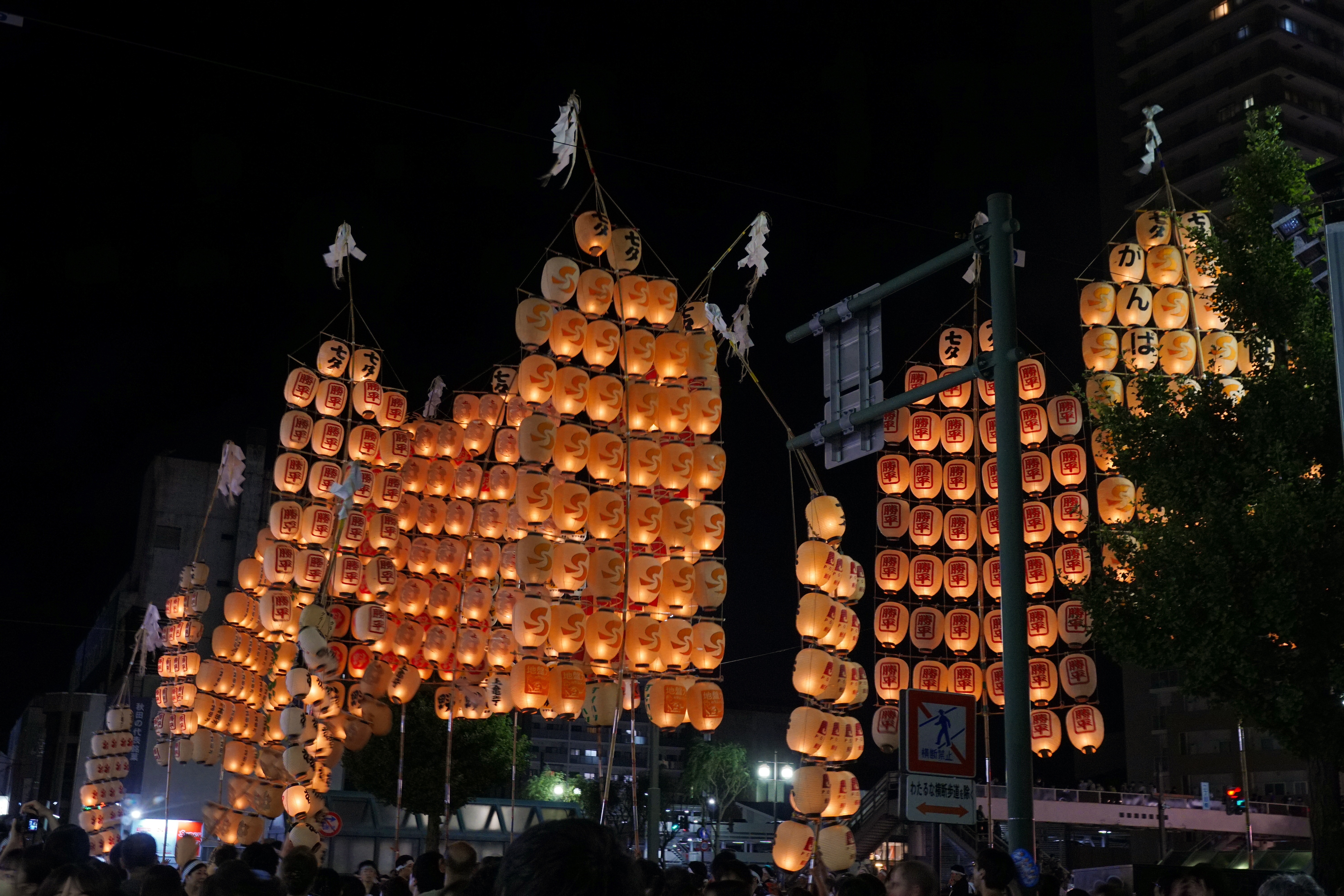 Tall illuminated lantern poles at the Akita Kanto Festival during a Tohoku summer festival itinerary