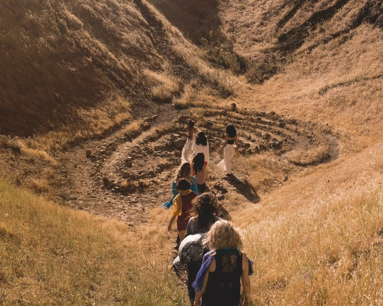 A group of women walking together towards a sacred natural place. 