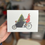 Thumbnail: Watercolour Christmas card of person with dog and tree in bakfiets, A6.