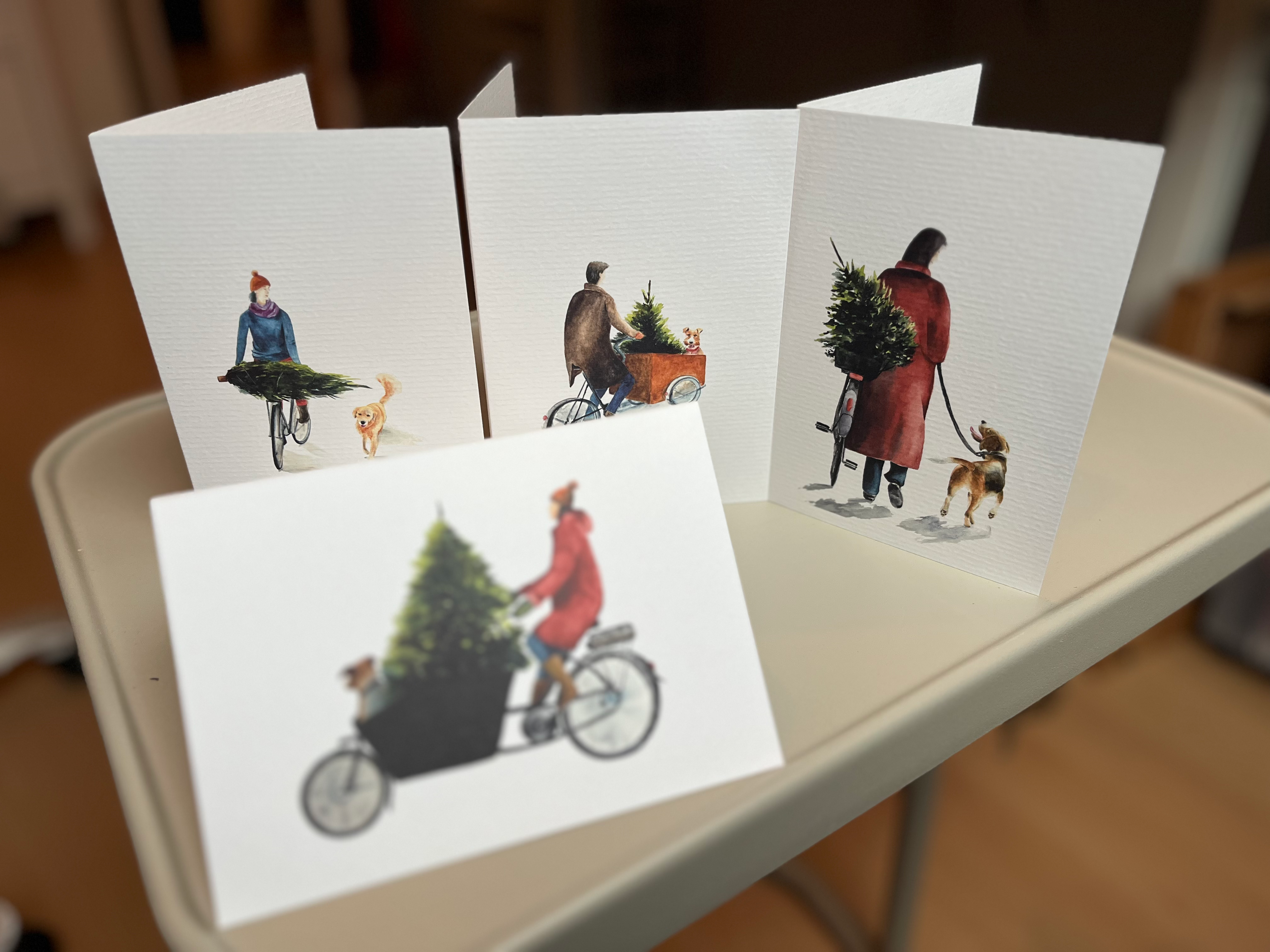 Set of four A6 watercolor Christmas cards with dogs, bikes and trees, FSC paper.