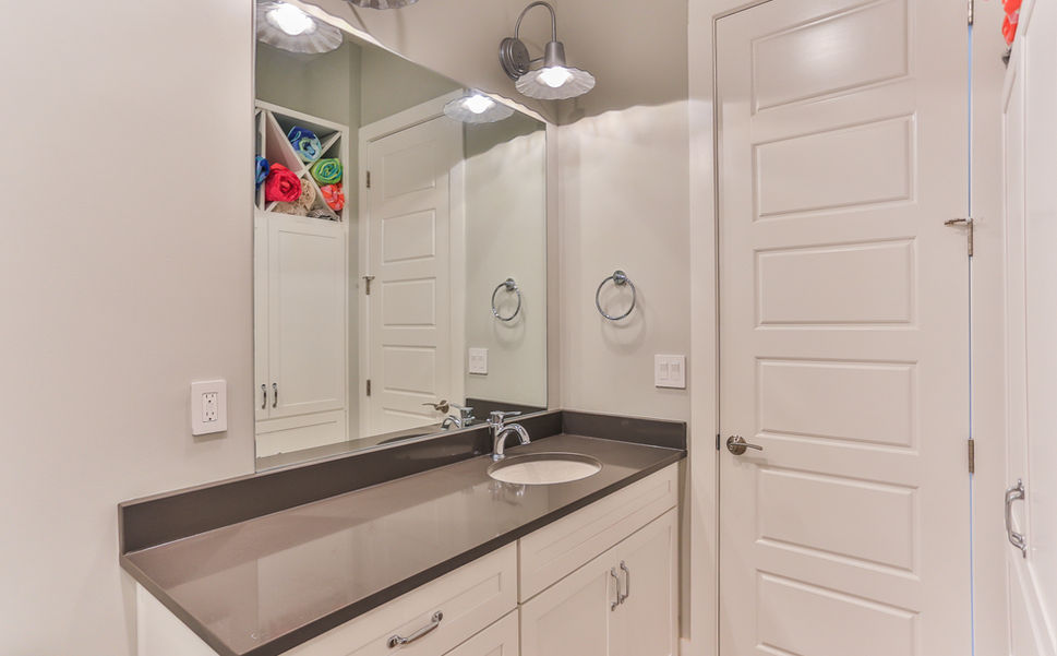 Remodeled bathroom with white double vanity and dark countertop in a Greensboro, MD home