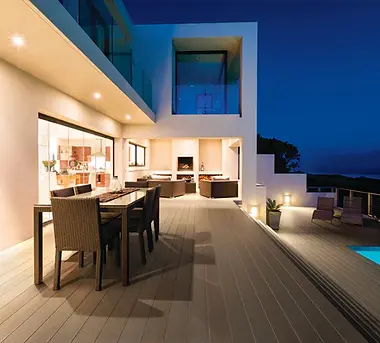 Modern house outdoor decking with pool at night.