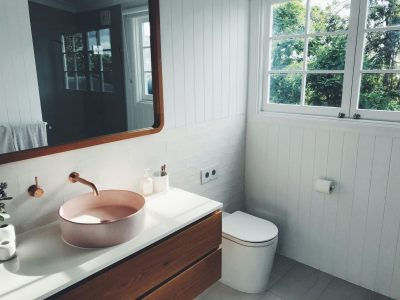 Custom bathroom renovation with teal subway tile surround, natural wood vanity, and vessel sink. Bay America Renovations custom tile and fixture installation serves Maryland's Eastern Shore and Anne Arundel County.