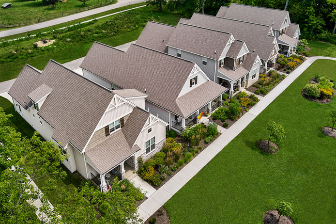Wide shot of a suburban home with a newly finished dark shingle roof.