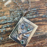Rectangular silver pendant with blue gemstones on chain