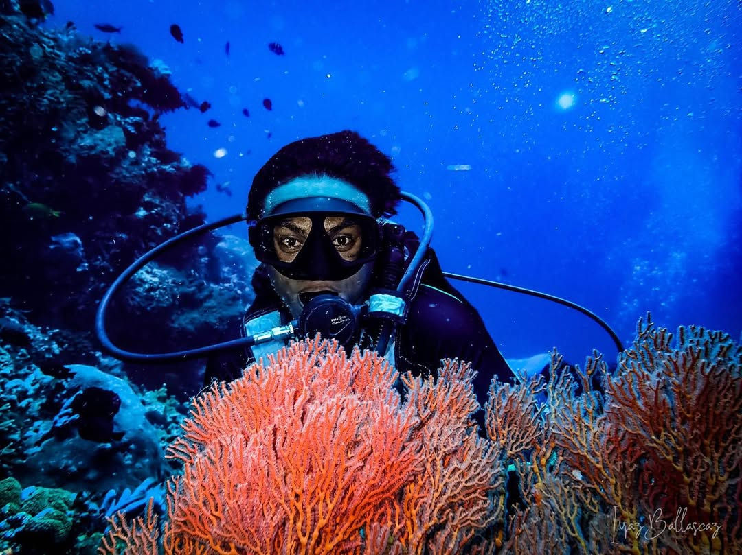 Diver take selfie behind coral reef