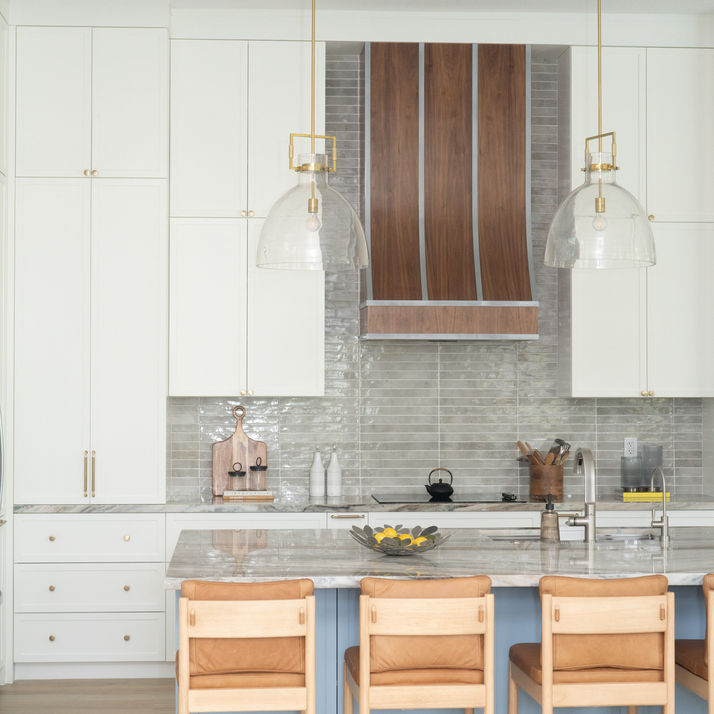 Elegant Miami kitchen design with a statement wood hood, white cabinetry, and a bold blue island.