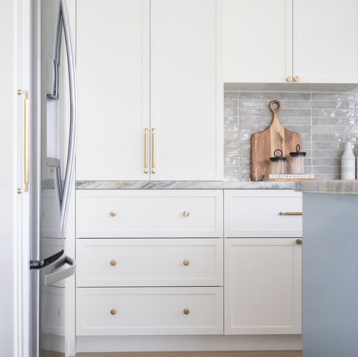 Transitional-style kitchen renovation with a hidden pantry, a striking blue island, and a warm wood hood.