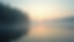 Eye-level view of a calm lakeside with morning mist