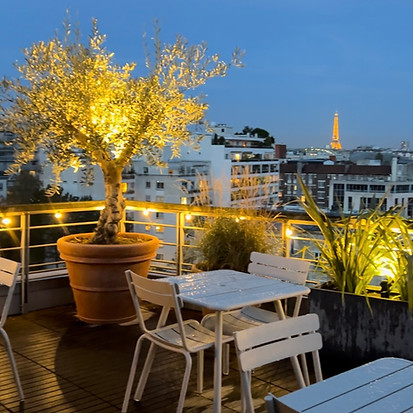 Terrasse d'entreprise avec vue sur la tour Eiffel, de beaux Oliviers dans des pots en terre cuite, avec un bel éclairage à Boulogne Billancourt