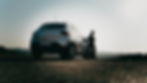 1 jante Dacia - un vehicul Dacia Duster de culoare alba cu un barbat sprijinit de portiera dreapta