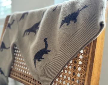 Beige cashmere throw blanket with dinosaur print
