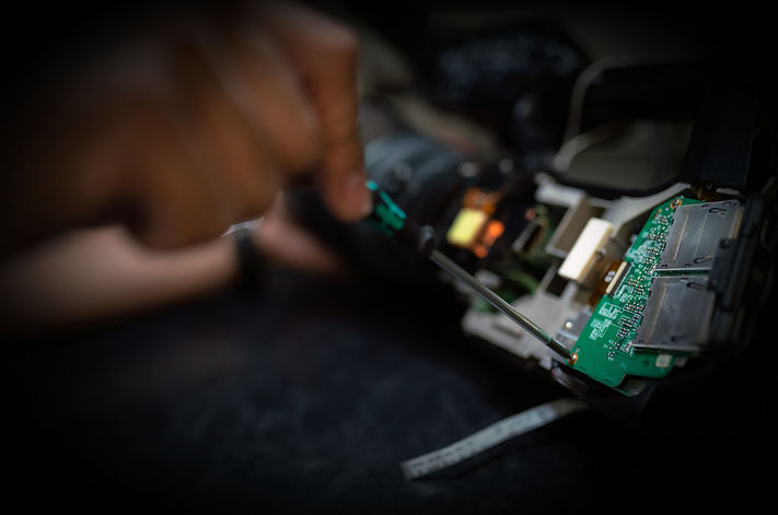 A dark image of someone working on computer hardware