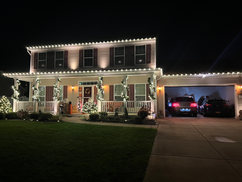 Warm white Christmas lighting on a home in Grand Island, NY with illuminated garland wrapped around the front posts.