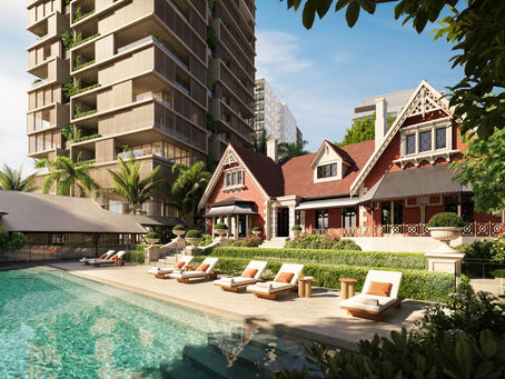 Luxury poolside with lounge chairs beside a red Victorian-style house and modern high-rise, framed by palms under a blue sky.