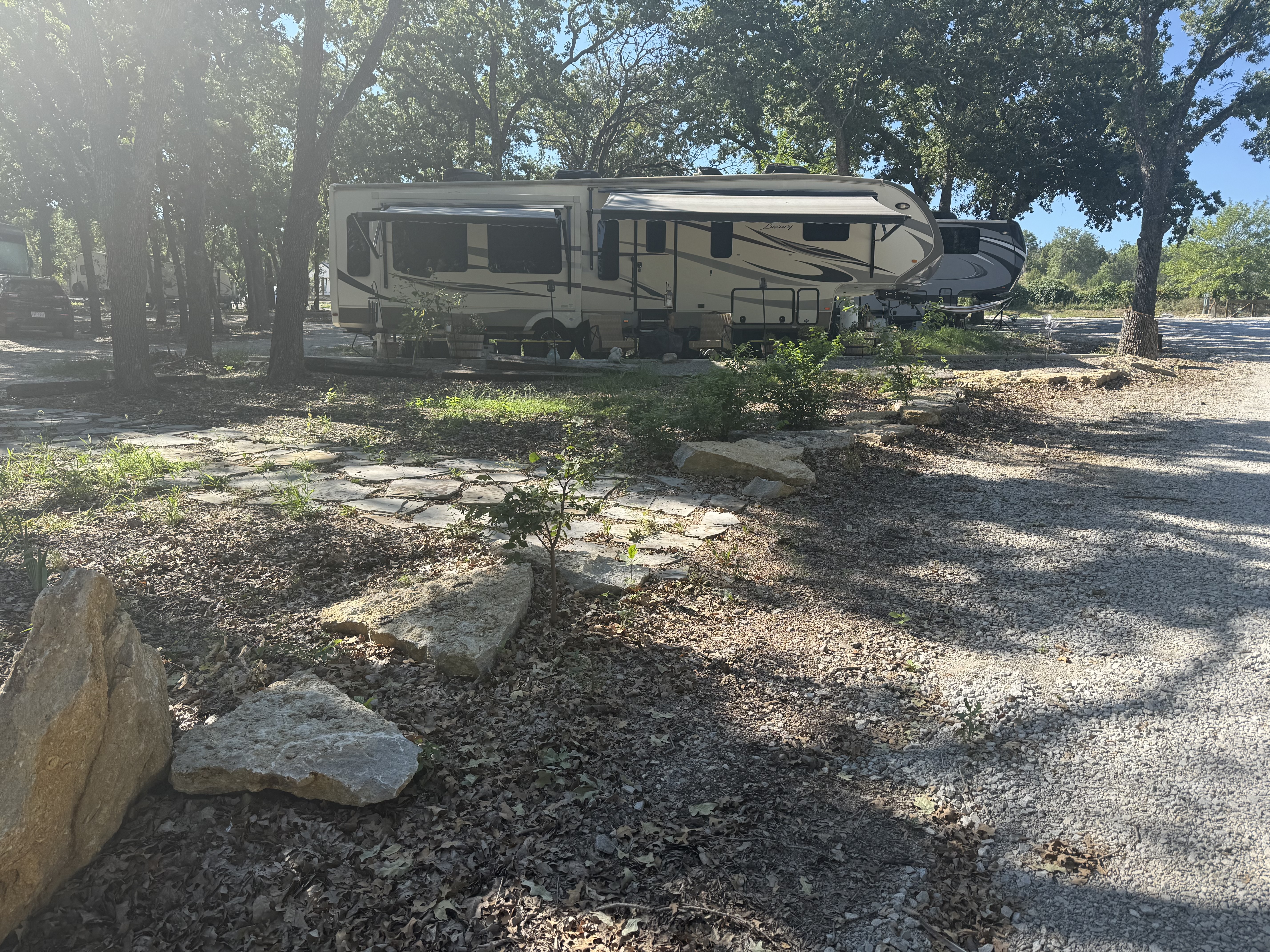 Wide angle view of a well-maintained RV park with multiple RVs parked and green lawns