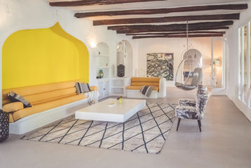 Bright living room with yellow sofa and traditional wooden beams in a Mallorca finca