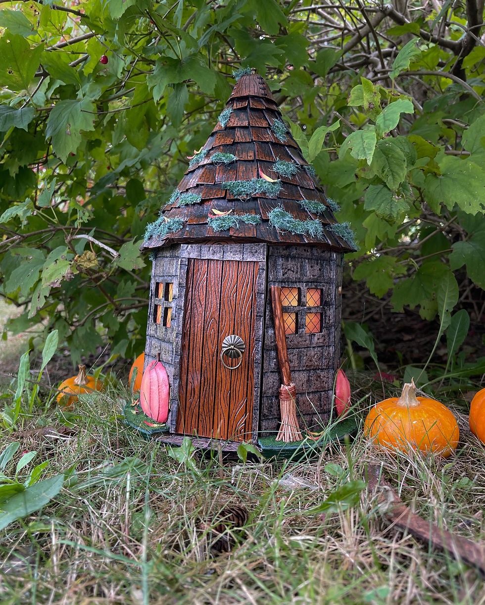 Handmade leather Groundskeeper's Hut bag displayed outdoors, featuring hand tooled stone walls, wood door, pumpkins