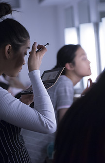 girls do their makeup backstage