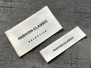 Dokuma tekstil marka etiketi örneği, gri kumaş zemin üzerinde minimal tasarımlı etiket