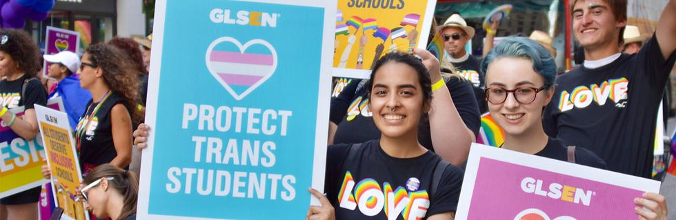 Student wearing a LOVE t-shirt holding GLSEN Protest Sign that states Protect Trans Students