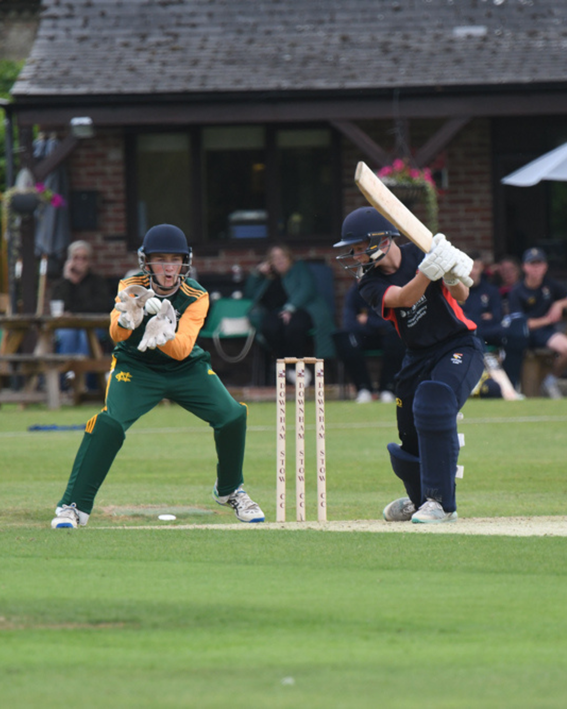 Wicket keeper catching the ball beside a batter