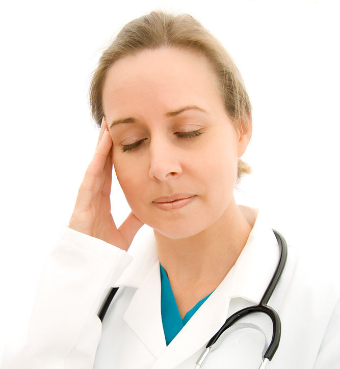 A doctor in a white coat with a stethoscope has closed eyes and a hand on her temple, expressing stress. Plain white background.