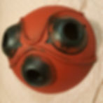 Mask with red paint base that is textured