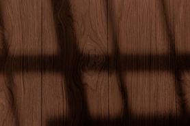 Shadows across a dark brown wooden floor. Light creates a patterned aesthetic.