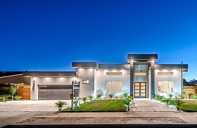 The front yard of a large modern home with a garage and driveway on Henry