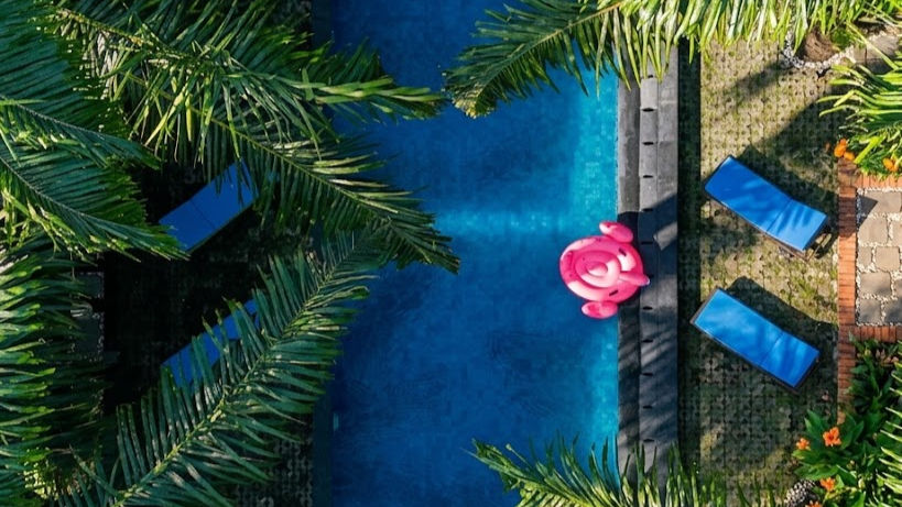 Eye-level view of a private resort chalet with an open-air living room and tropical garden