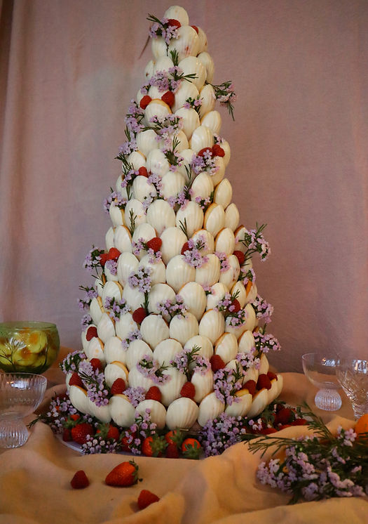 Madeleine tower coated in white, styled with flowers at a wedding and fruit