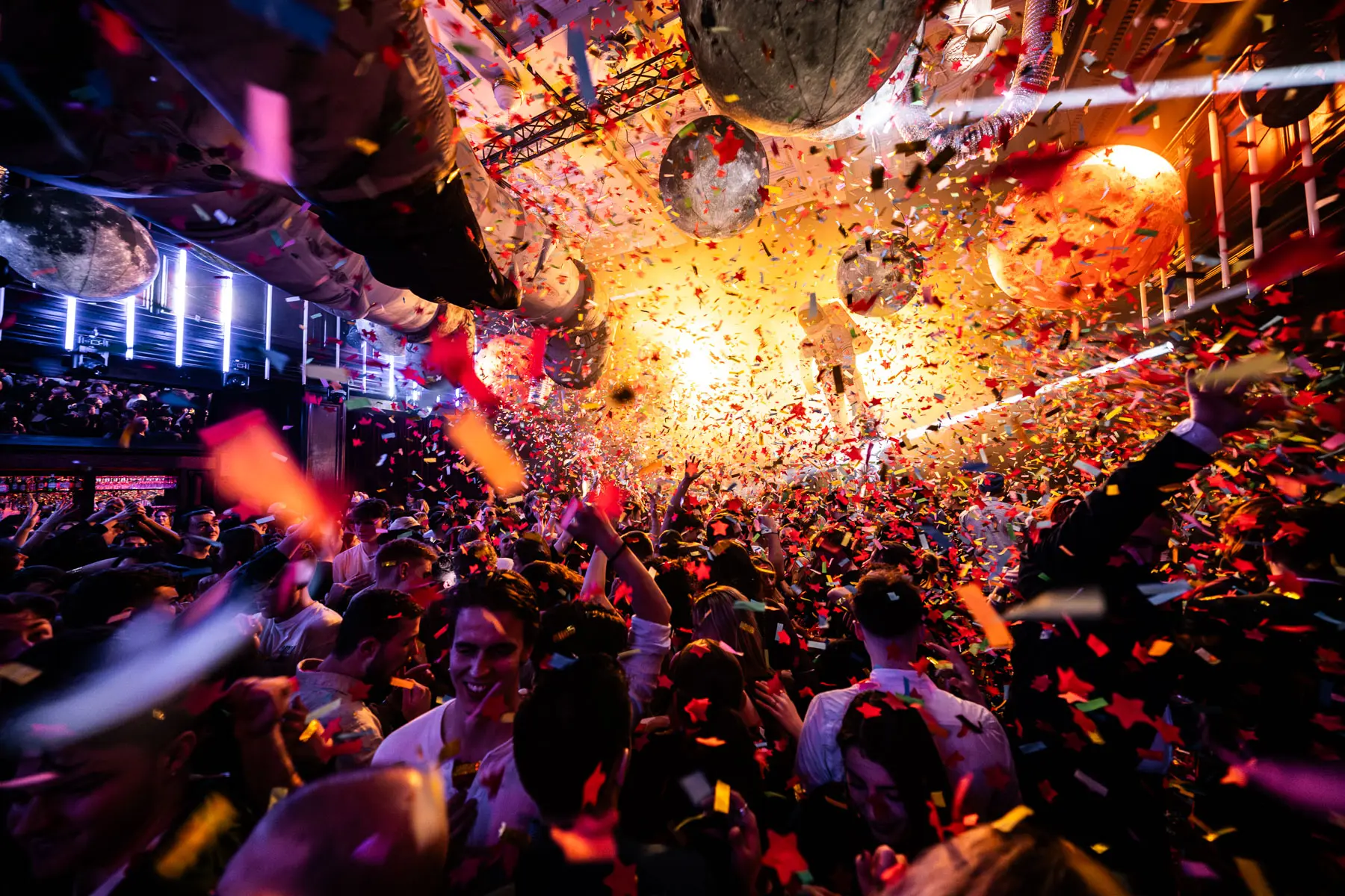 Kleine Planeten als Dekoration in einem Nachtclub bei einer Party mit Viel Konfetti