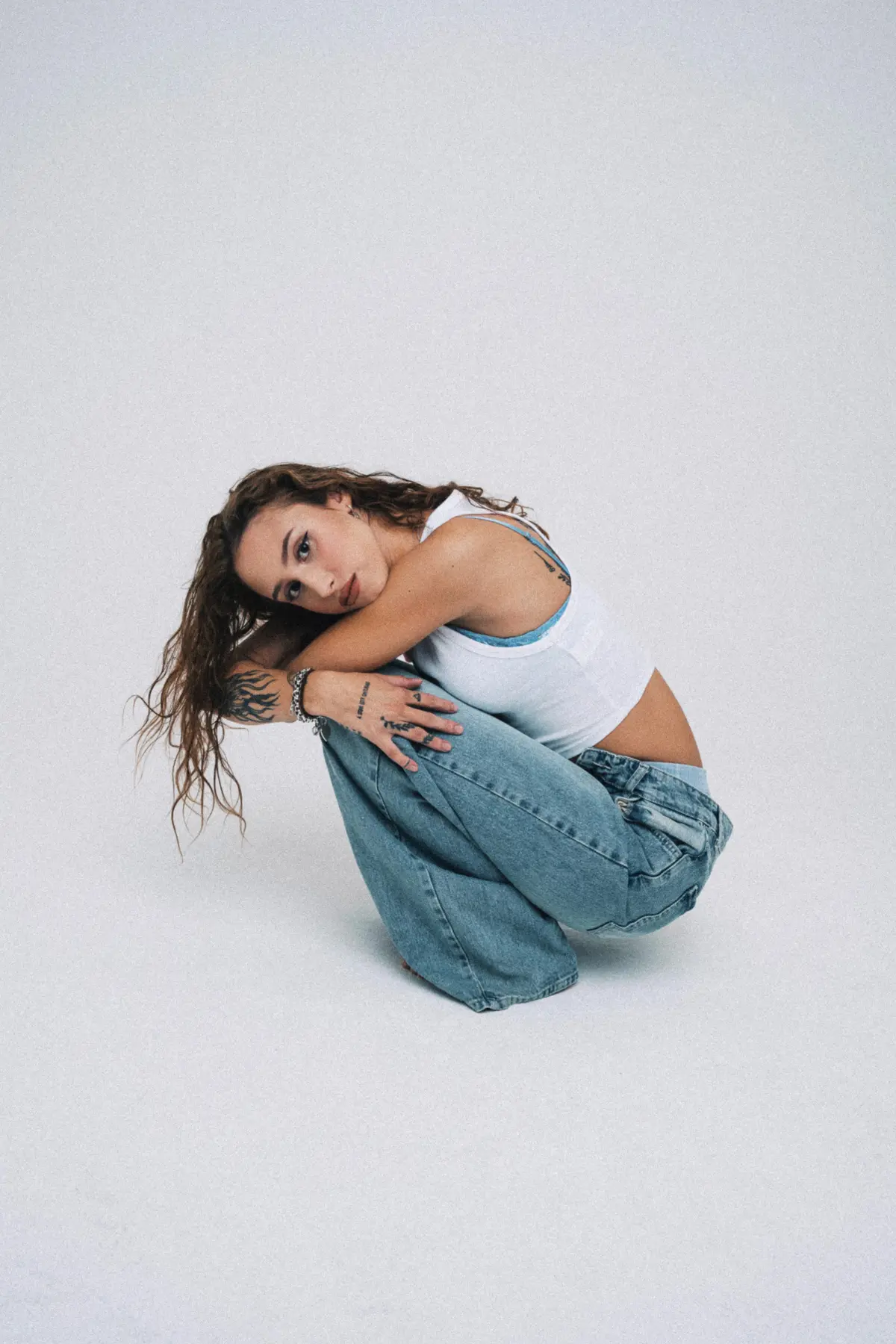 Frau mit Braunen Haaren Hockt in einem Fotostudio