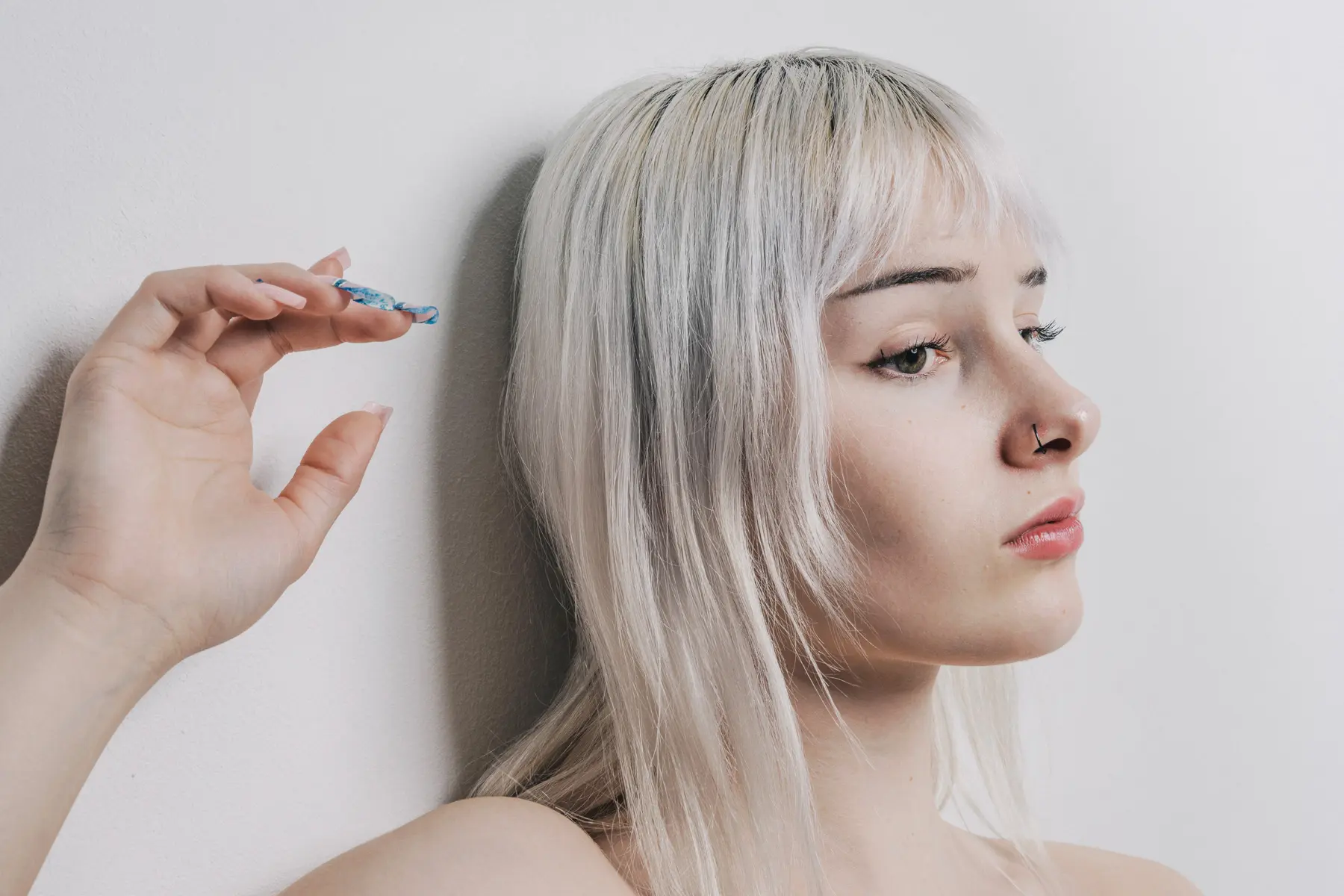Frau mit Hellen Haaren und Hand an der Wand