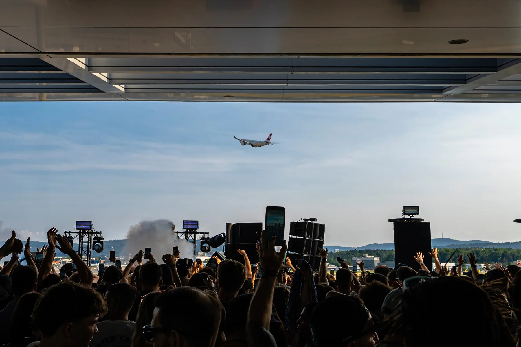 Flughafenparty mit jubelden menschen und flugzeug im Hintergrund