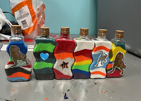 a collection of 6 bottles should the layered colored sand project