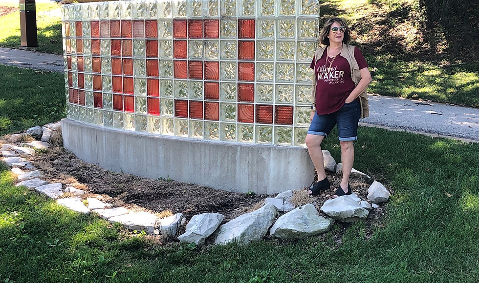 Standing with the UMSL sign.