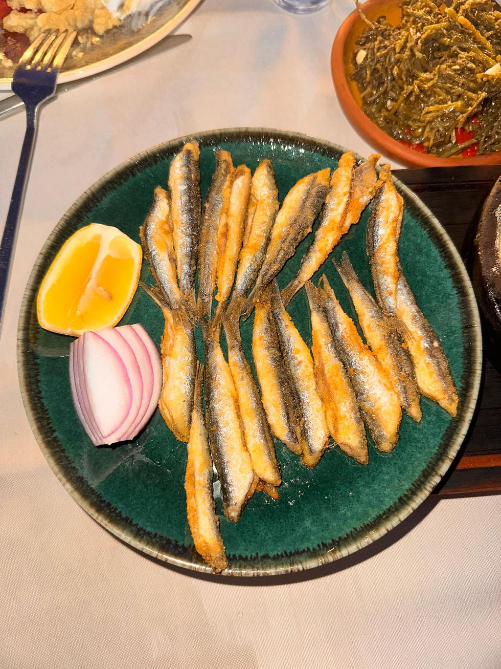 Traditional Black Sea pan-fried fresh anchovies served with lemon and red onion