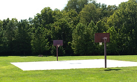 Two basketball goals at Flat Run Veterans Park with backdrop of trees