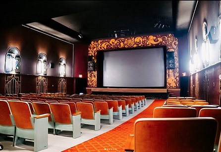 Interior view of the Rohs Theatre showing rows of seats, movie screen and art deco light fixtures and decor