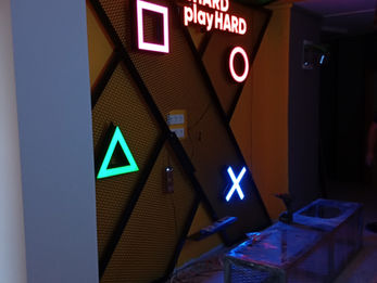Çelik karkas ve baklava dilimli metal file üzerine monte edilmiş PlayStation sembolleri ile ışıklı slogan duvar konsepti uygulaması.