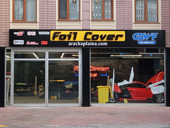 Foil Cover araç kaplama merkezi dış cephesinde yer alan siyah zeminli ışıklı kutu harf tabela ve dükkan alınlığı üzerinde folyo markalarının pleksi kesim logoları.