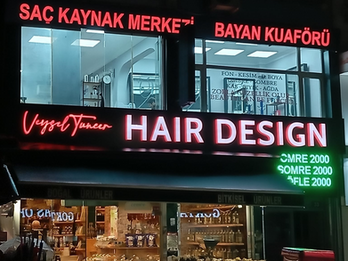 Veysel Tuncer Hair Design bayan kuaför salonu için hazırlanan mat siyah kompozit dış cephe giydirme, fileli ışıklı kutu harf tabela ve yeşil LED fiyat panosu.
