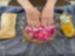 Hands soaking in rose petals at a Nail Salon Baton Rouge