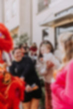 Women and baby watching a red lion dance