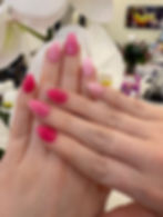 Pink striped and polka dot manicured nails from a nail salon