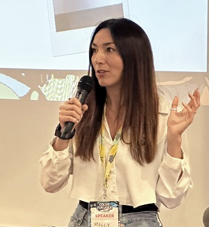Molly Maine speaking at Colive Fukuoka 2024, sharing her experiences as a digital nomad and freelance illustrator with an engaged audience.